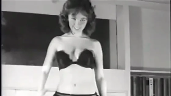 Vintage model in erotic lingerie undresses in front of the camera and shows off a gorgeous figure