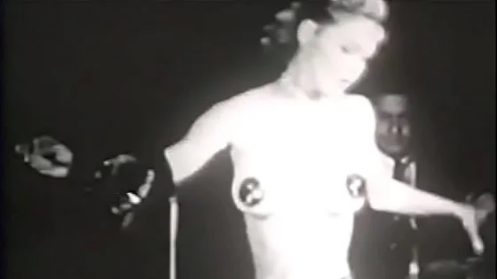 Beautiful vintage burlesque babe stripping on stage with pasties on