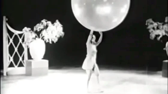 Vintage babe on stage with props doing strip routine