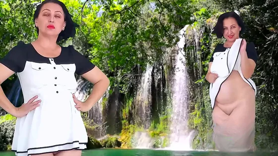 A pretty lady in a short dress shows a striptease outdoor. Pussy and ass. Waterfall 2
